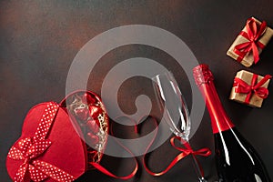 Valentine`s day greeting card with champagne glasses and love gift box on stone background. Top view with space for your greeting