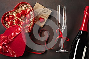 Valentine`s day greeting card with champagne glasses and love gift box on stone background. Top view with space for your greeting