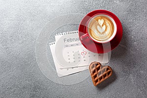 Valentine`s day greeting card with coffee cup and heart shaped cookies on grey background. Top view with space for your greetings