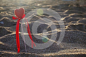 Valentine`s day greeting card concept, red heart on pristine sandy beach, honeymoon vacation background.