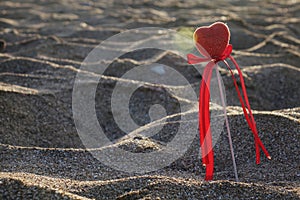Valentine`s day greeting card concept, red heart on pristine sandy beach, honeymoon vacation background.