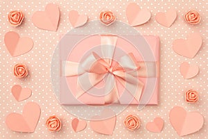 Valentine`s day greeting card with decorated paper heart, coral or pink rose flowers and coral gift box. Top view. Flat lay