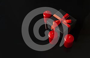 Valentine`s Day holiday background with a black gift box and red candles