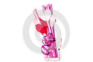 Valentine`s day holiday. bright pink drinking straws with hearts and a pink ribbon in a glass isolated on white.bright sipping st