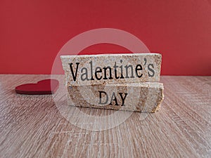 Valentine\'s Day, the inscription on the brick blocks on the background of a red heart. Beautiful red and wooden background