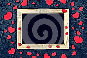 Valentine`s Day. Layout for the postcard. Wooden frame blank and hearts on a black stone background