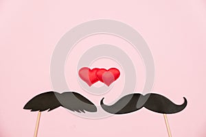 Valentine`s day lgbt, love, romantic concept. Red hearts with couple paper mustache props on pink background. Greeting card. Flat