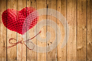 Valentine`s day love heart yarn on wood stick over wood background