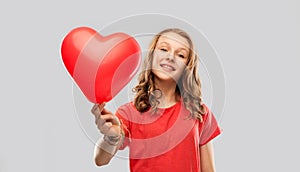 Smiling teenage girl with red heart shaped balloon