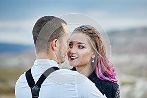 Valentine`s day loving couple in nature hugs and kisses, man and woman love each other. Mountains of Cappadocia in Turkey