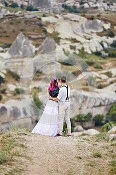 Valentine`s day loving couple in nature hugs and kisses, man and woman love each other. Mountains of Cappadocia in Turkey