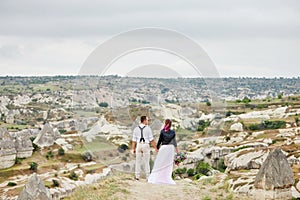 Valentine`s day loving couple in nature hugs and kisses, man and woman love each other. Mountains of Cappadocia in Turkey