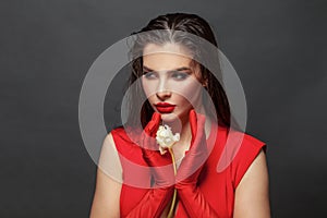 Valentine`s Day. Loving woman. Beautiful female model in a red dress on black. Red lipstick makeup