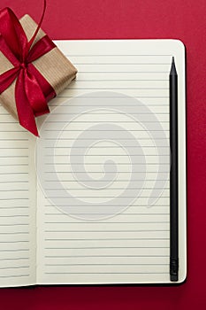 Valentine's Day mock up. Open notebook with gift boxe, on red background, copy space for text