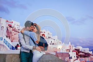 Valentine`s day in Oia. Couple in love enjoying honeymoon on Santorini island Greece at sunset. Vacation and traveling