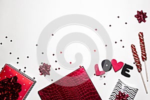 Valentine`s day party creative composition. Gifts, heart shape, confetti, sweets, black and red decorations on white background.