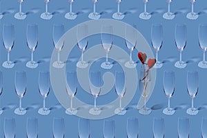 Valentine`s day pattern. Copy image of an empty champagne glass on a light blue background.