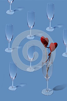 Valentine`s day pattern. Copy image of an empty champagne glass on a light blue background.