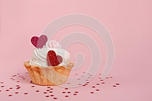 Valentine`s day pink background. Vanilla cupcake decorated red heart candle