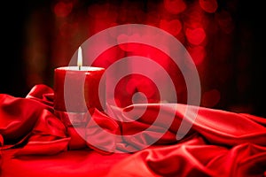 Valentine's Day. Red candle on red silk