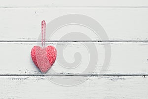 Valentine`s Day. Red heart on a white wooden rustic background from boards. Top view, flat lay, copy space.Toned image