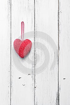 Valentine`s Day. Red heart on a white wooden rustic background from boards. Top view, flat lay, copy space.Vertical frame
