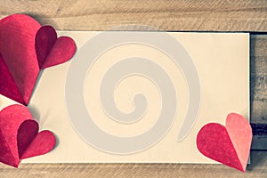 Valentine`s day red hearts with blank notepad on brown wooden table