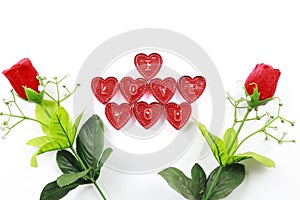 Valentine`s Day red roses with heart shaped i love you candles on isolated white background.