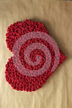 Valentine`s Day. Red and white hearts on craft paper background. Beautiful red heart of roses, felt handmade. Beauty