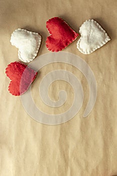Valentine`s Day. Red and white hearts on craft paper background. Beautiful red heart of roses, felt handmade. Beauty