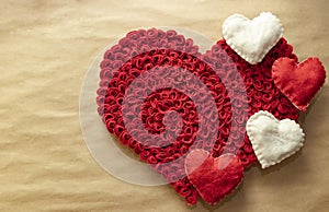 Valentine`s Day. Red and white hearts on craft paper background. Beautiful red heart of roses, felt handmade. Beauty