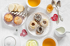 Valentine's day romantic Breakfast. Lemon green tea and sweets - banana muffins, cookies with caramel and nuts, donuts l