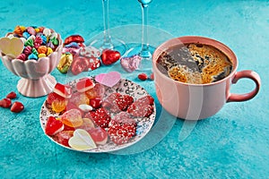 Valentine's day or romantic dinner with candy hearts, a cup of hot coffee and elegant table seting