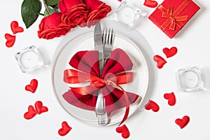 Valentine`s day romantic dinner concept. Beautiful table setting. Roses and candles on a white background