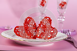 Valentine`s day romantic dinner with red hearts on pink background