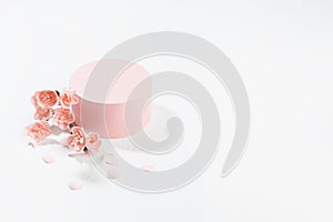 Valentine`s Day stage mockup with pink cylinder podium and twig of gentle sakura flowers, petals on light white wood background.