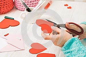 Valentine's day theme. Female hands cut the heart out of the pap