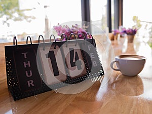 Valentine`s day theme with wooden block calendar and hot coffee in cafe