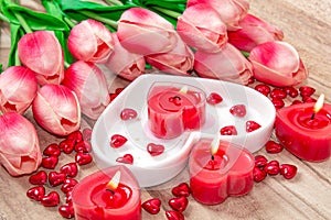 Valentine`s Day Tulips, a heart-shaped plate and a heart-shaped candle.