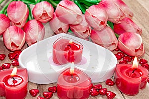 Valentine`s Day Tulips, a heart-shaped plate and a heart-shaped candle.