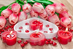 Valentine`s Day Tulips, a heart-shaped plate and a heart-shaped candle.