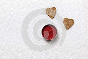 Valentine`s Day. Two hearts and a candle on white snow