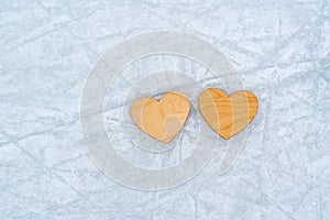 Valentine's day  two wooden hearts lie on the ice skated rink