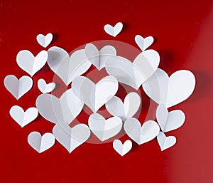 Valentine`s Day vintage background, white paper hearts on red background