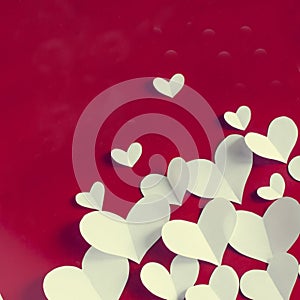 Valentine`s Day vintage background, white paper hearts on red background