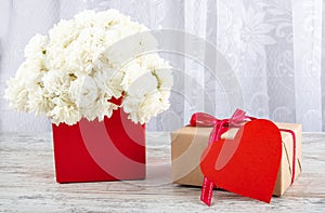 Bouquet of white roses in a red box and a symbol of the heart for the inscription.