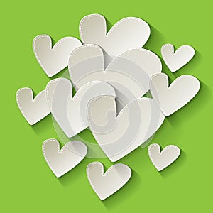 Valentine`s day white paper hearts on a green background.