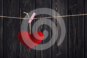 Valentine`s Red heart on rope on wooden background