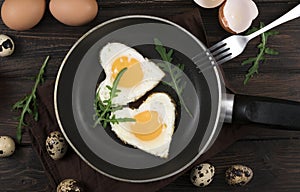 Valentines breakfast in heart shaped cast iron pan of two raw eggs and yolks