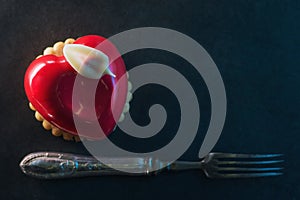 Valentines cake with heart shape with metal fork on black backgrount, produkt photography for patisserie